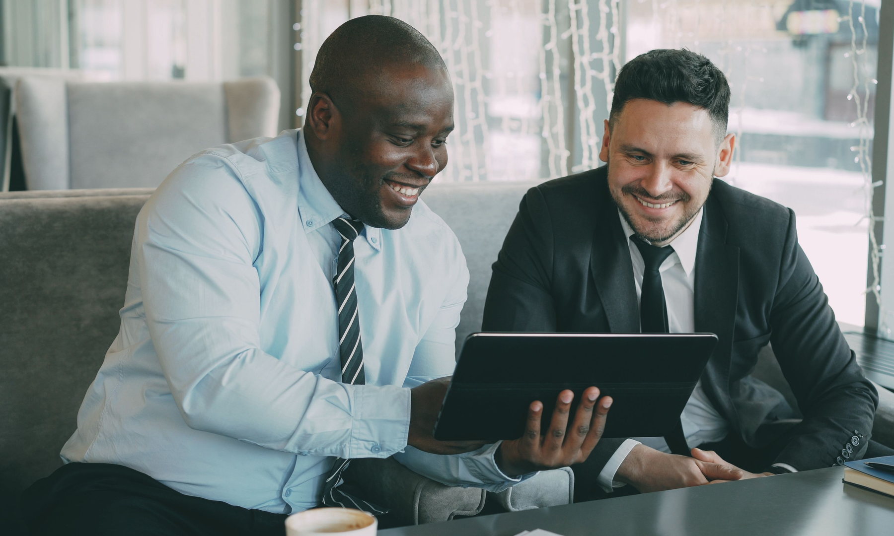 Two business leaders reviewing a digital platform together on a tablet