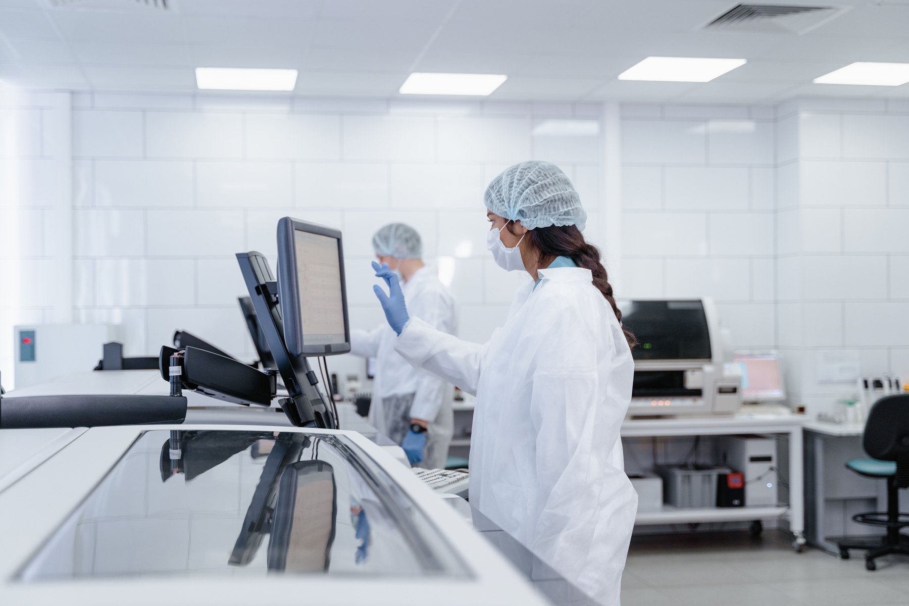 Laboratory professionals coordinating work with equipment and digital systems