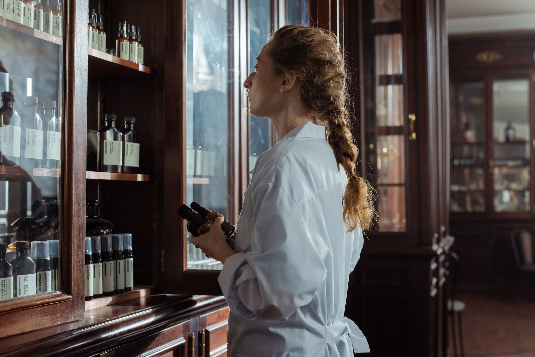 A pharmacy professional reviewing medicines in a dispensary environment